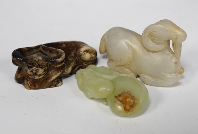 A Chinese pale green jade gourd pendant, a Chinese jade white and russet jade figure of a recumbent goat and a Chinese hardstone recumbent figure of an ox, largest 6cm wide (3)., Condition - good